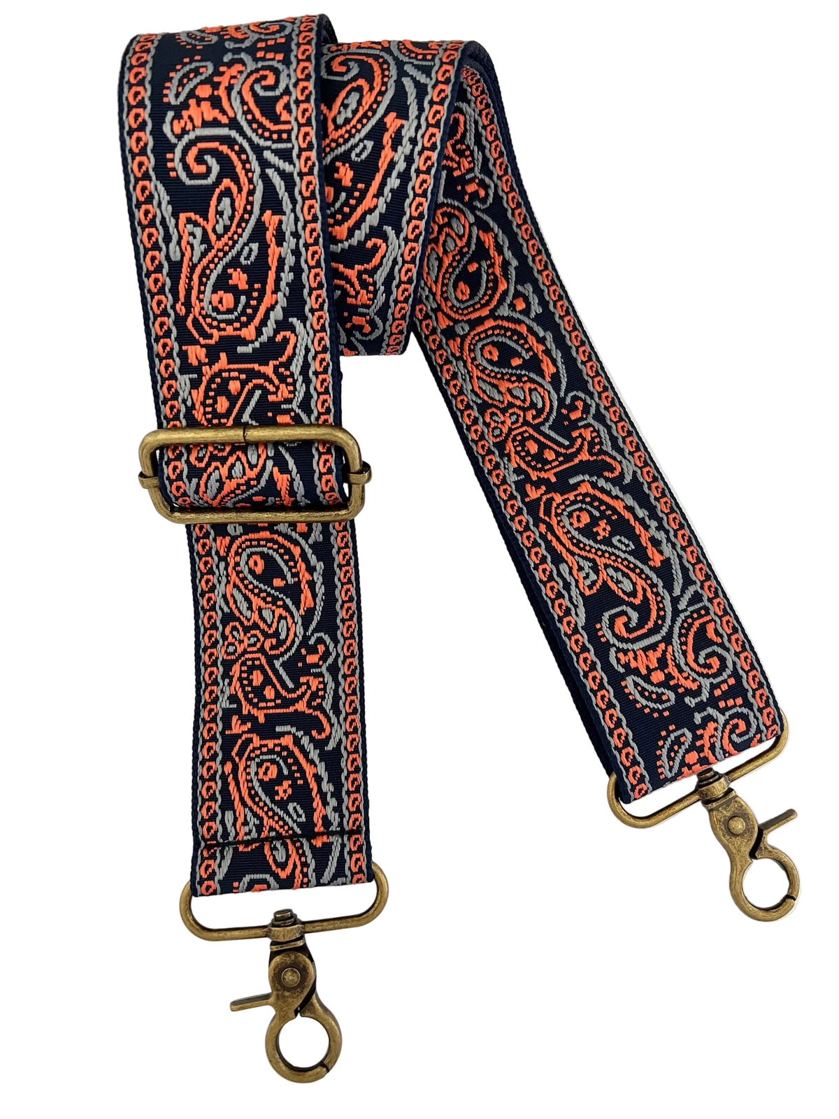 Coral and light blue paisley pattern on a navy adjustable bag strap with bronze hardware on a white background